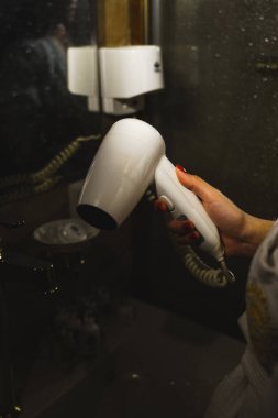 Seksi kadın duştan sonra saçını kurutuyor. Kişisel hijyen kavramı.