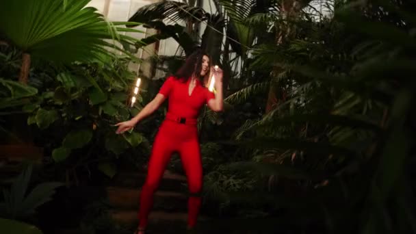 Kırmızı Elbiseli Hoş Bir Kadın Tropik Bir Bahçede Dans Ediyor — Stok video