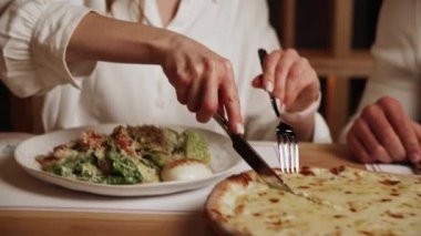 Aşık genç bir çift kokteyl içer ve bir kafede pizza yer. Yaşam tarzı konsepti 4k