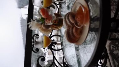 Dağlardaki otel balkonunda yeni yıl kahvaltısı. Kruvasan, meyve suyu ve mandalinalı kahve karlı dağların arka planında. Kış tatili kavramı