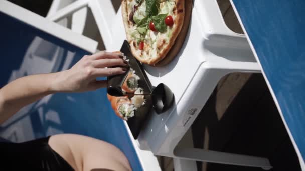 黒水着のセクシーな女性は プールの近くで寿司とピザを食べます ホテルホリデーコンセプト バーティカルビデオ — ストック動画