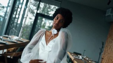 A dark-skinned bride in a white dress poses in the mountains on the terrace. Wedding concept. Portrait of a dark-skinned bride 4k
