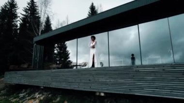 A dark-skinned bride in a white dress poses in the mountains on the terrace. Wedding concept. Portrait of a dark-skinned bride 4k