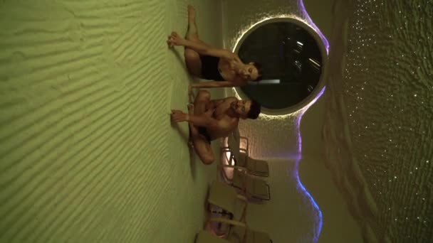 若い男女が塩室でリラックスする ウェルネスホリデーコンセプト バーティカルビデオ — ストック動画