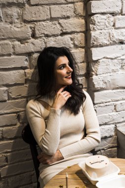 Kahve içip doğum gününü kutlayan mutlu bir kadın. Bir buket lale ve bento kekiyle. Doğum günü hediyesi.