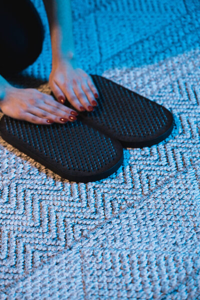 Женщина в спортивной одежде стоит на ногтях Садху дома. Концепция практики гвоздя. Духовное развитие