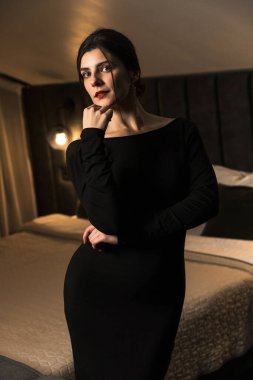 Siyah elbiseli, dairede poz veren zarif bir kadın. Moda çekim konsepti