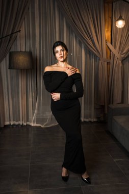 Siyah elbiseli, dairede poz veren zarif bir kadın. Moda çekim konsepti