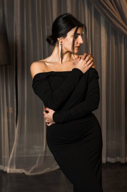 Siyah elbiseli, dairede poz veren zarif bir kadın. Moda çekim konsepti