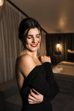 Siyah elbiseli, dairede poz veren zarif bir kadın. Moda çekim konsepti