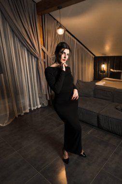 Siyah elbiseli, dairede poz veren zarif bir kadın. Moda çekim konsepti