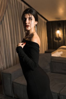 Siyah elbiseli, dairede poz veren zarif bir kadın. Moda çekim konsepti