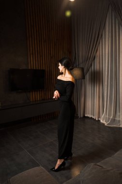 Siyah elbiseli, dairede poz veren zarif bir kadın. Moda çekim konsepti