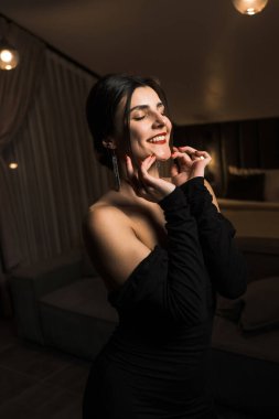 Siyah elbiseli, dairede poz veren zarif bir kadın. Moda çekim konsepti