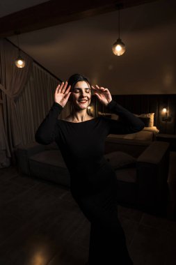 Siyah elbiseli, dairede poz veren zarif bir kadın. Moda çekim konsepti