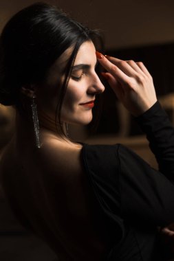 Siyah elbiseli, dairede poz veren zarif bir kadın. Moda çekim konsepti