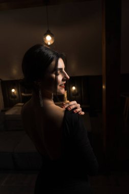 Siyah elbiseli, dairede poz veren zarif bir kadın. Moda çekim konsepti