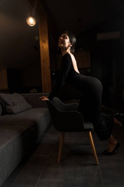 Siyah elbiseli, dairede poz veren zarif bir kadın. Moda çekim konsepti