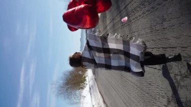 Aşık bir çift seyahat ederken romantik bir randevu yaşıyor. Bir adam ve bir kadın karlı dağların arka planında poz veriyor, çay içiyorlar. Seyahat konsepti. Dikey video