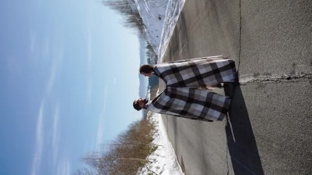 恋するカップルは旅行中にロマンチックなデートをする 男と女が雪山の背景に立って お茶を飲んでいる 旅行コンセプト バーティカルビデオ — ストック動画