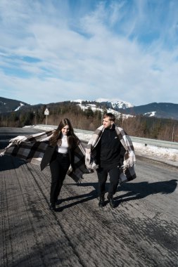 Aşık bir çift seyahat ederken romantik bir randevu yaşıyor. Bir adam ve bir kadın karlı dağların arka planında poz veriyor, çay içiyorlar. Seyahat kavramı