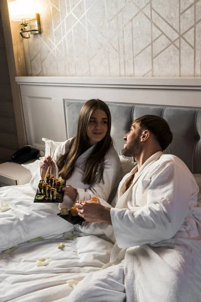 Couple in love eating sushi in bed.Valentine\'s day concept