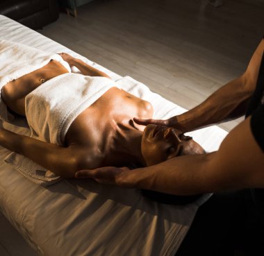 Profesyonel bir masör genç bir kadına masaj yapar. Güzeller güzeli genç bir kadın masaj salonundan zevk alır. Güzellik, cilt bakımı, iyi olmak. Masaj ve spa tedavisi kavramı.