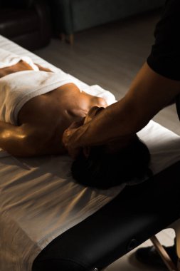 Profesyonel bir masör genç bir kadına masaj yapar. Güzeller güzeli genç bir kadın masaj salonundan zevk alır. Güzellik, cilt bakımı, iyi olmak. Masaj ve spa tedavisi kavramı.