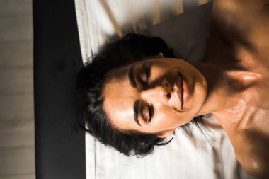 Profesyonel bir masör genç bir kadına masaj yapar. Güzeller güzeli genç bir kadın masaj salonundan zevk alır. Güzellik, cilt bakımı, iyi olmak. Masaj ve spa tedavisi kavramı.