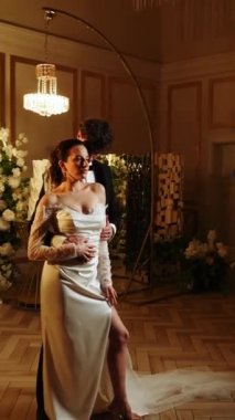 Gelin ve damat düşen karda ilk dansı yaparlar. Düğün günü. İlk düğün dansının konsepti. Dikey video. 4k