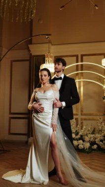 Gelin ve damat düşen karda ilk dansı yaparlar. Düğün günü. İlk düğün dansının konsepti. Dikey video. 4k