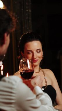 Birbirine aşık bir çiftin romantik yemeği. Bir adam ve bir kadın bir restoranda birlikte akşam yemeği yiyorlar. Adam kıza evlenme teklif etmiş. Kız da evet demiş. Evlilik teklifi konsepti. Dikey video