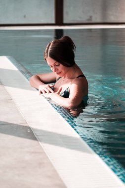 Mayolu seksi kadın havuzda yüzüyor. Kadın spa 'da rahatlıyor. Otelde rahatlama konsepti.