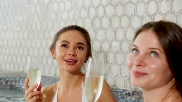 两个性感女人喝着香槟 穿着一件夹克放松一下 女人在说话时放松一下 — 图库视频影像