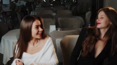 İki genç kadın bir restoranda yemek yiyor. İki arkadaşla buluşmak ve birlikte yemek yemek. Restoran konsepti