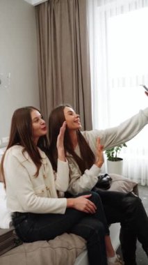 İki genç kadın tatile çıkıyor. Bir kadın otele yerleşiyor, gülüyor ve selfie çekiyor. Dikey video