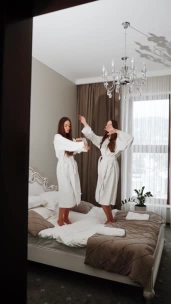 Twee Jonge Vrouwen Badjassen Dansen Het Bed Filmen Zichzelf Hotel — Stockvideo