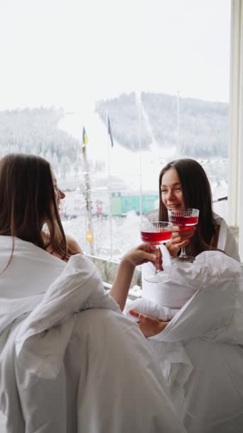 Две Молодые Женщины Одеялах Пьют Красные Коктейли Веселятся Балконе Видом — стоковое видео