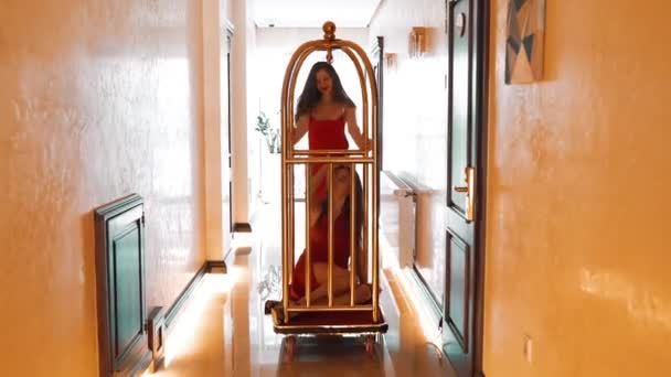 Zwei Sexy Frauen Roten Kleidern Fahren Auf Einem Goldenen Gepäckwagen — Stockvideo