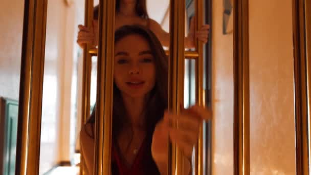 Dwie Seksowne Kobiety Czerwonych Sukienkach Jeżdżą Złotym Wózku Bagażowym Hotelu — Wideo stockowe