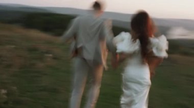 Gelin ve damat gün batımında güzel tarlalarda ve tepelerde yürür, güler ve dans ederler. Düğün günü konsepti