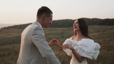 Gelin ve damat gün batımında güzel tarlalarda ve tepelerde yürür, güler ve dans ederler. Düğün günü konsepti