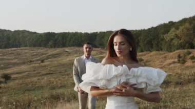 Gelin ve damat gün batımında güzel tarlalarda ve tepelerde yürür, güler ve dans ederler. Düğün günü konsepti