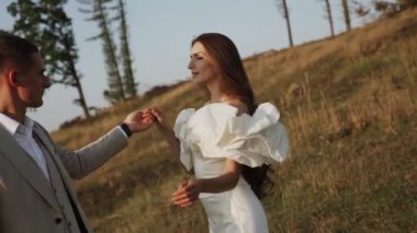 Gelin ve damat gün batımında güzel tarlalarda ve tepelerde yürür, güler ve dans ederler. Düğün günü konsepti