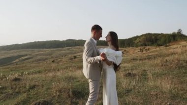 Gelin ve damat gün batımında güzel tarlalarda ve tepelerde yürür, güler ve dans ederler. Düğün günü konsepti