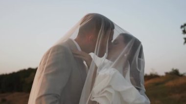 Gelin ve damat gün batımında güzel tarlalarda ve tepelerde yürür, güler ve dans ederler. Düğün günü konsepti