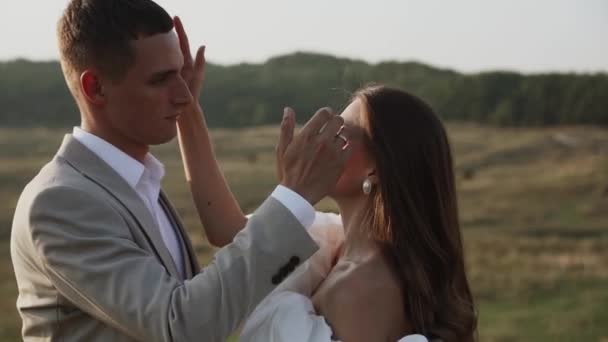 Das Brautpaar Spaziert Bei Sonnenuntergang Durch Wunderschöne Felder Und Hügel — Stockvideo