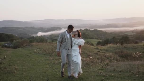 신부와 신부는 아름다운 필드와 언덕을 일몰에 웃음과 결혼식 — 비디오