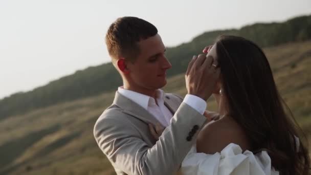 Das Brautpaar Spaziert Bei Sonnenuntergang Durch Wunderschöne Felder Und Hügel — Stockvideo