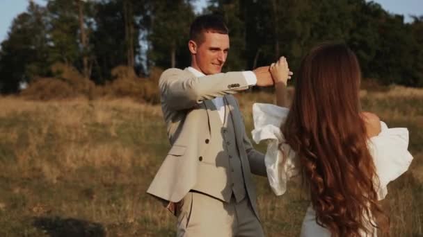 Menyasszony Vőlegény Sétálnak Napnyugtakor Gyönyörű Mezők Dombok Nevetni Táncolni Esküvőnapi — Stock videók